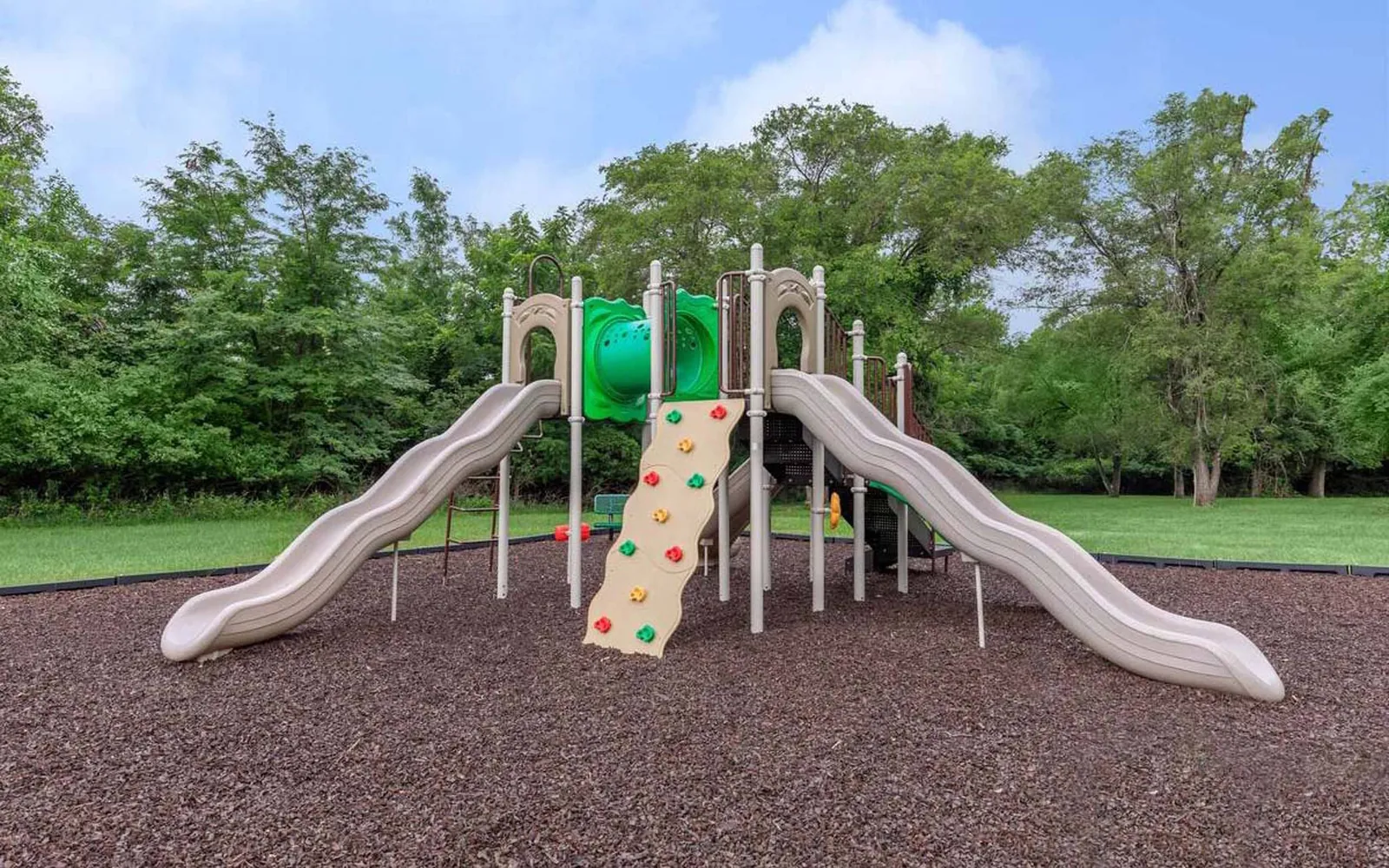 Arbors of Grandview - a playground with trees behind it