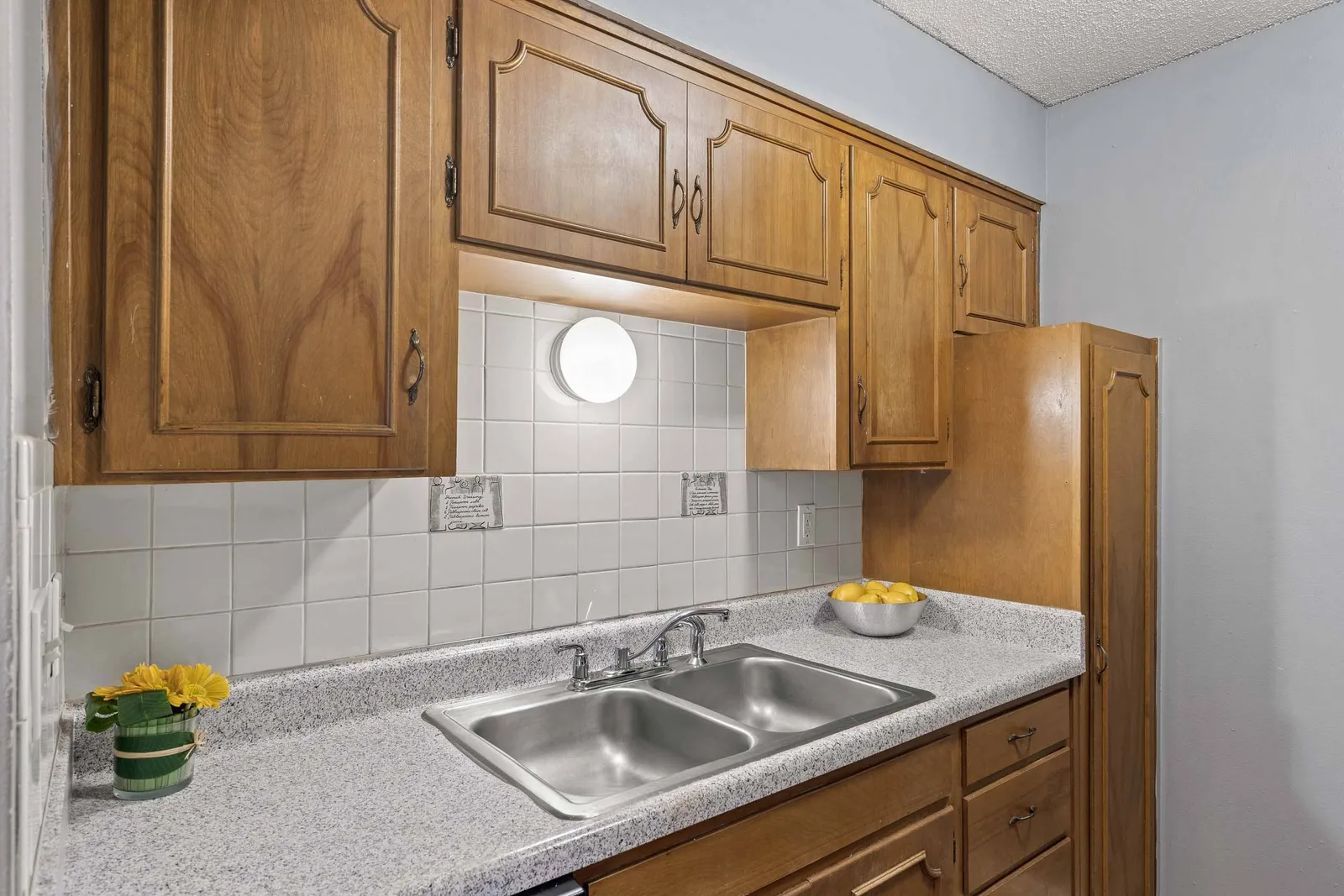 Forest Park Apartments - a kitchen with a sink and cabinets above it