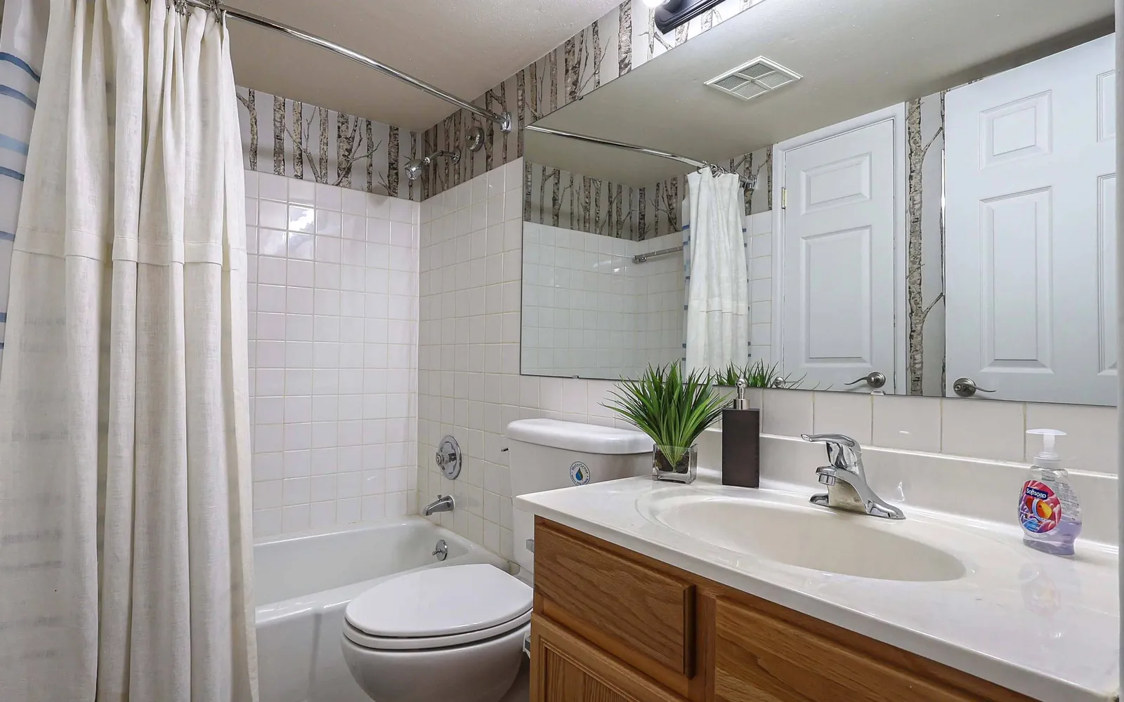 Grant 79 Apartment Homes - a bathroom with a sink, toilet, and tub shower
