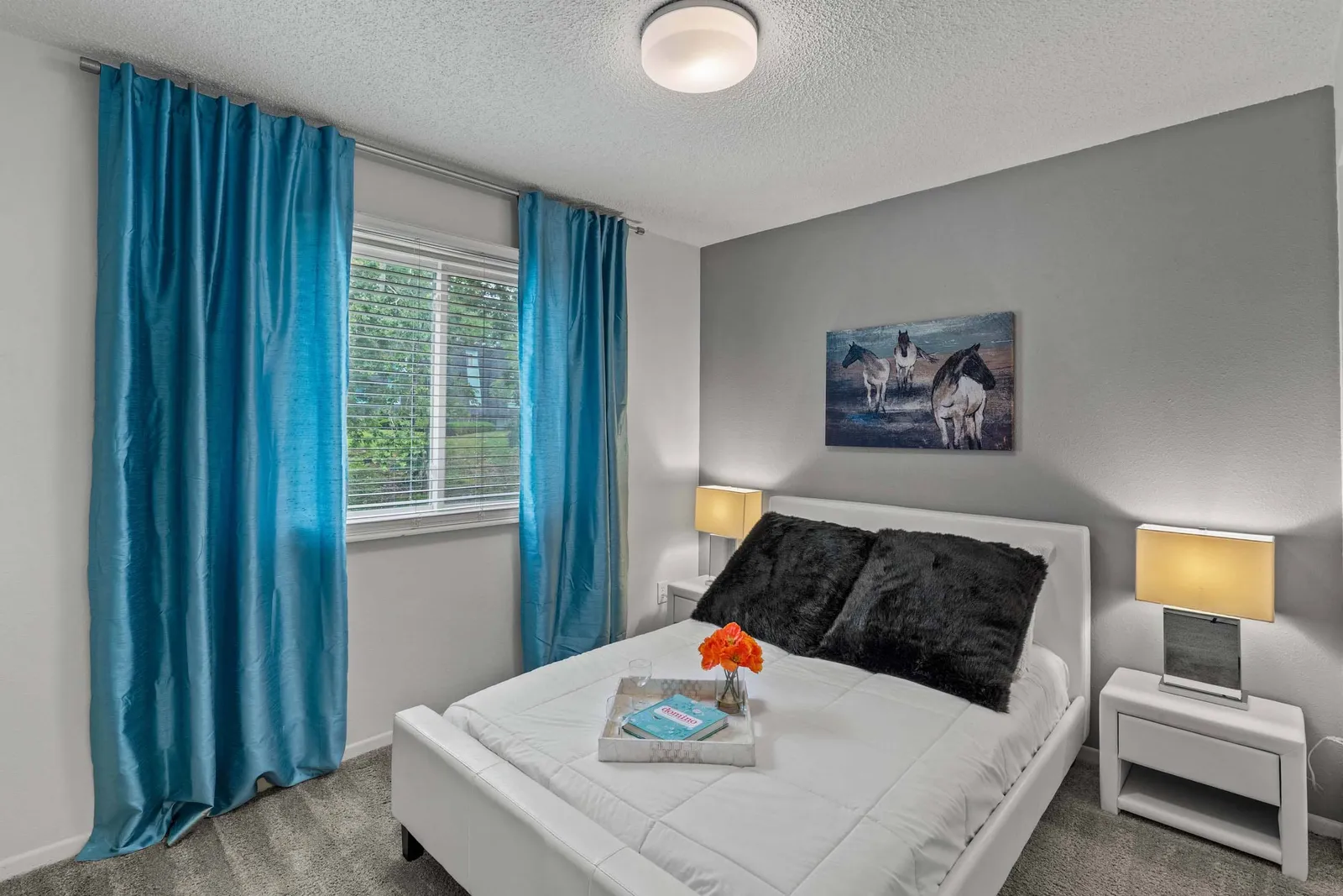 Nori Apartments - a bedroom with a window and blue curtains