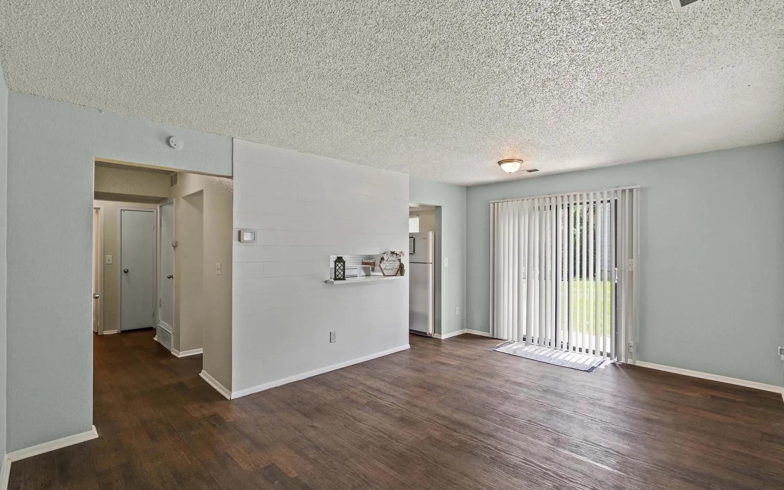 Prairie Walk Apartment Homes - a living room with sliding door windows