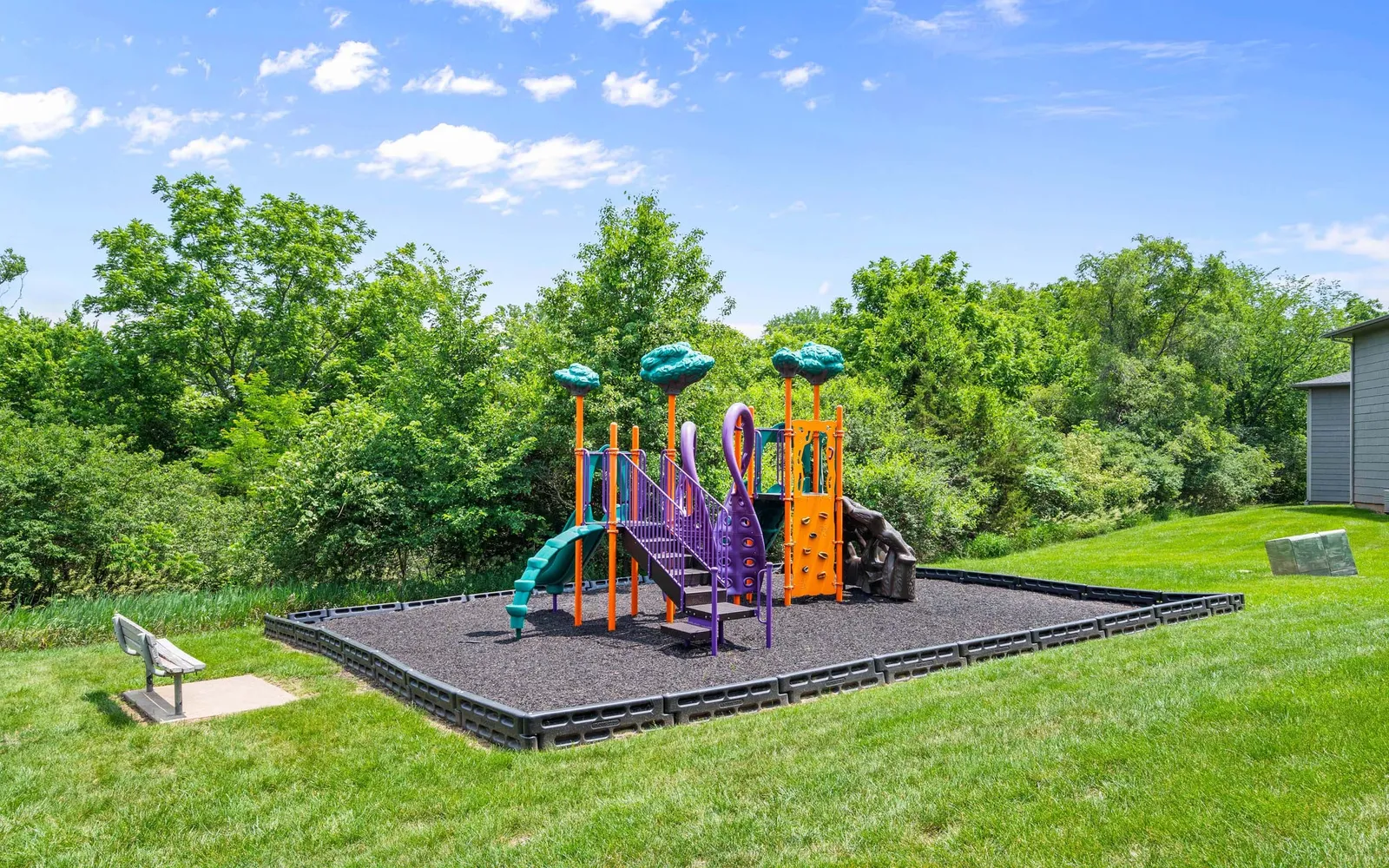 Prairie Walk Apartment Homes - a playground surrounded by grass and trees