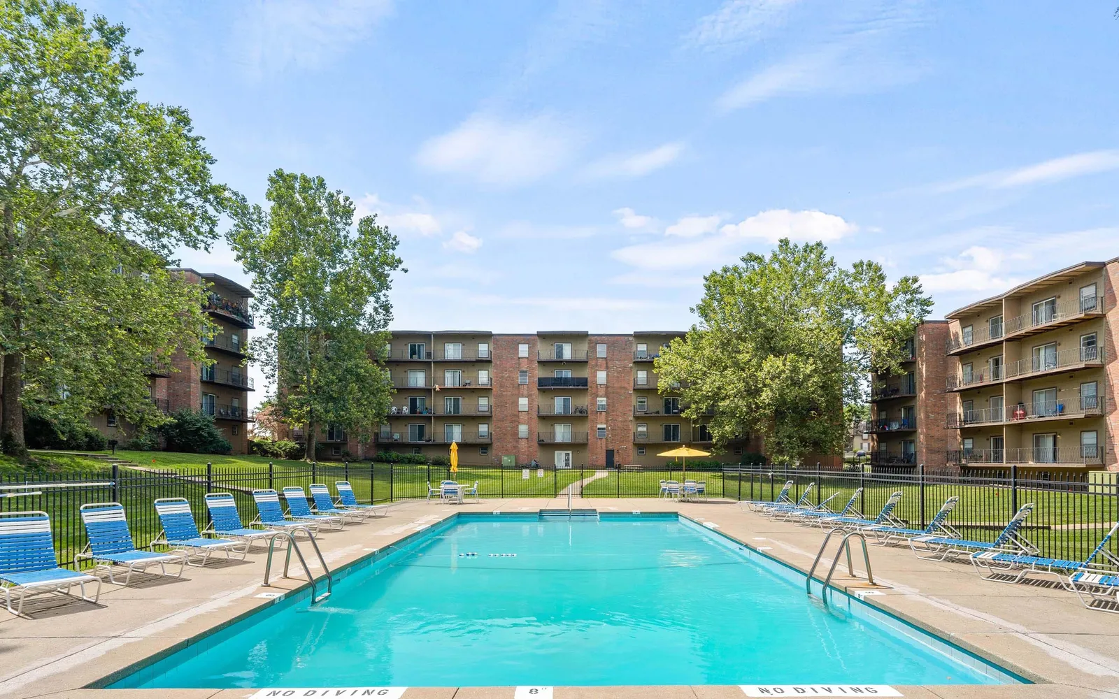 Ridge at Chestnut Apartments - a swimming pool surrounded by buildings and trees