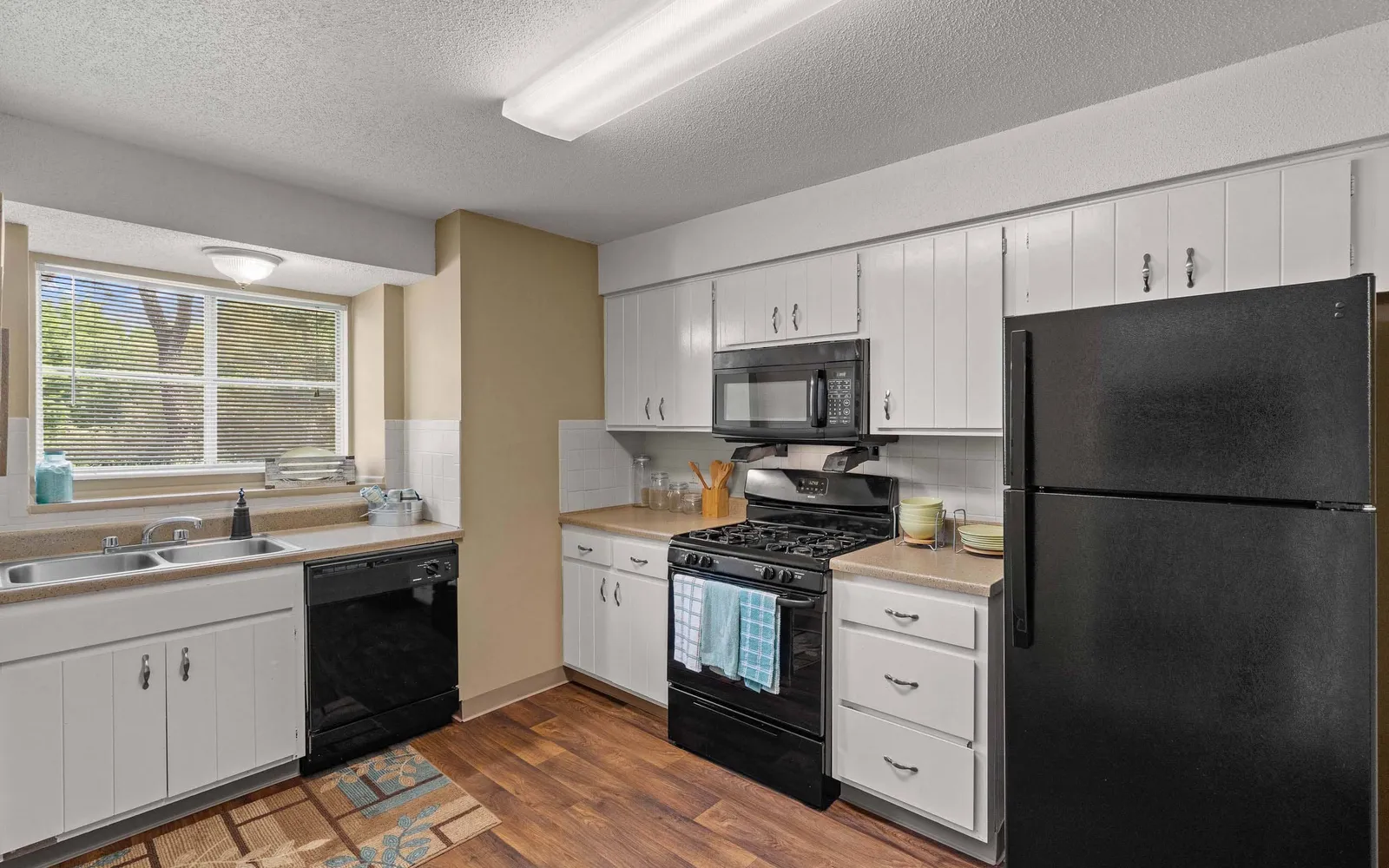 Ridge at Chestnut Apartments - a kitchen with appliances and white cabinets