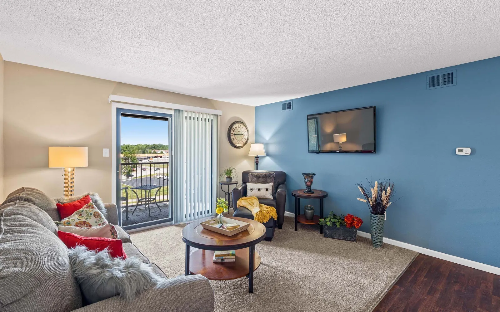 The Hills Apartments - a living room with a blue wall and furniture