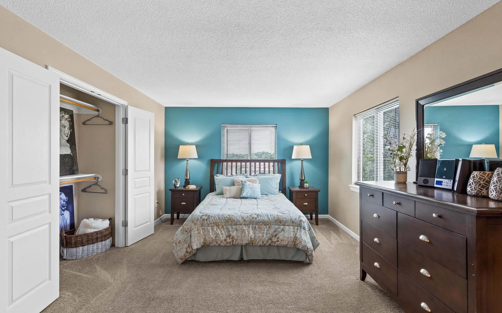 The Hills Apartments - a bedroom with furniture and a blue wall