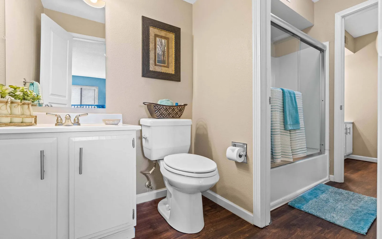 The Hills Apartments - a bathroom with a toilet, shower, and sink