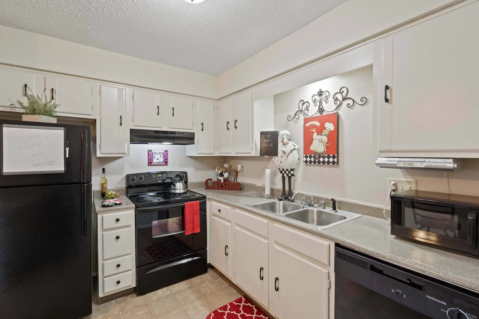 The Oaks at Prairie View - a kitchen with light cabinets and black appliances