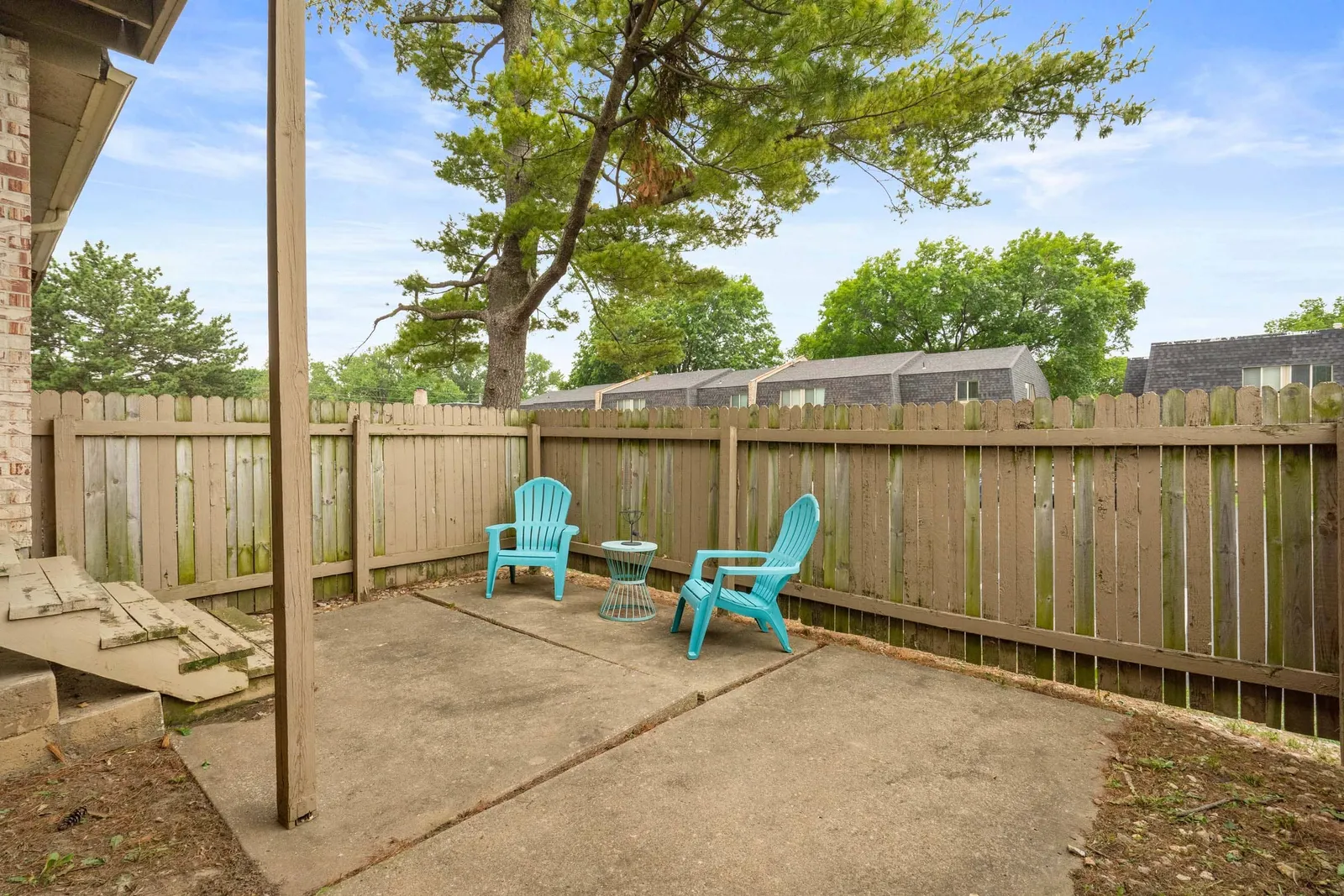 The Oaks at Prairie View - a fenced in patio with two chairs and small table