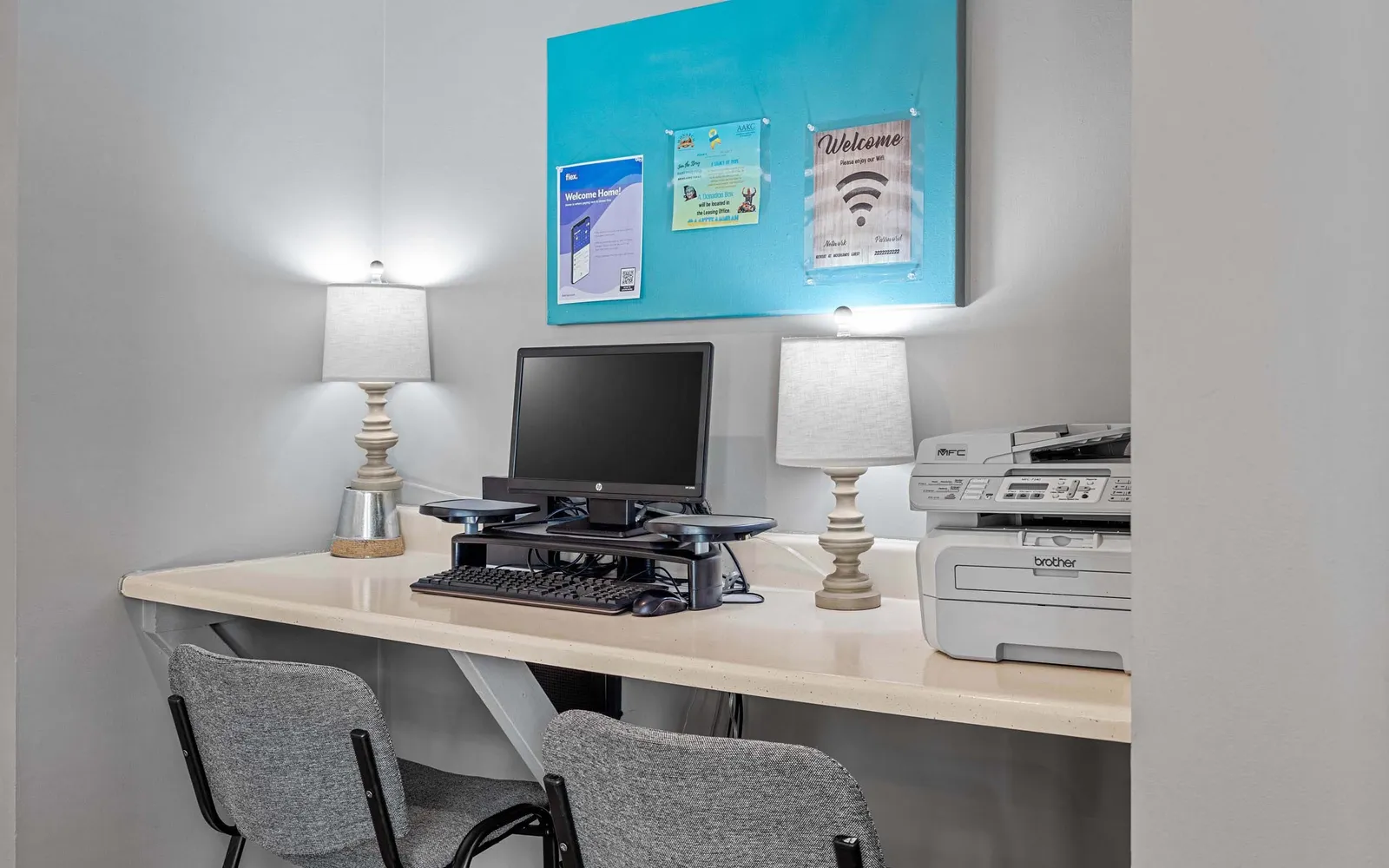 The Retreat at Woodlands - a desk with a computer, two laps, and a printer