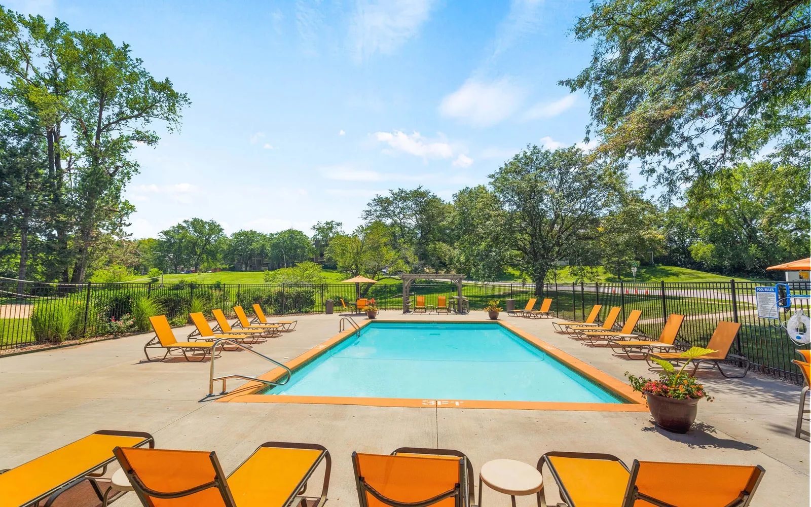 The Retreat at Woodridge - a pool with chairs and trees around it