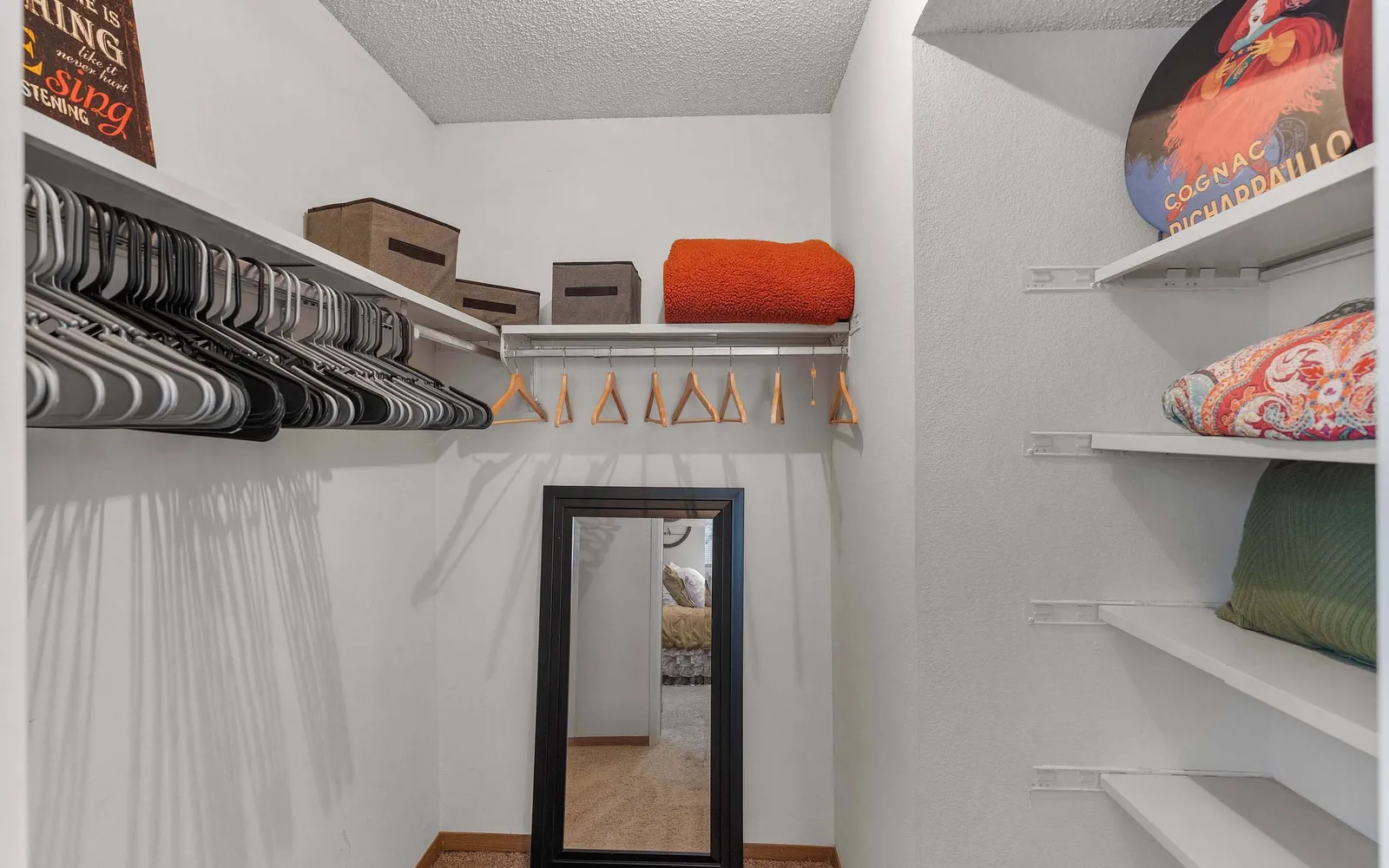 The Retreat at Woodridge - a walk in closet with shelves, hangers, and a mirror