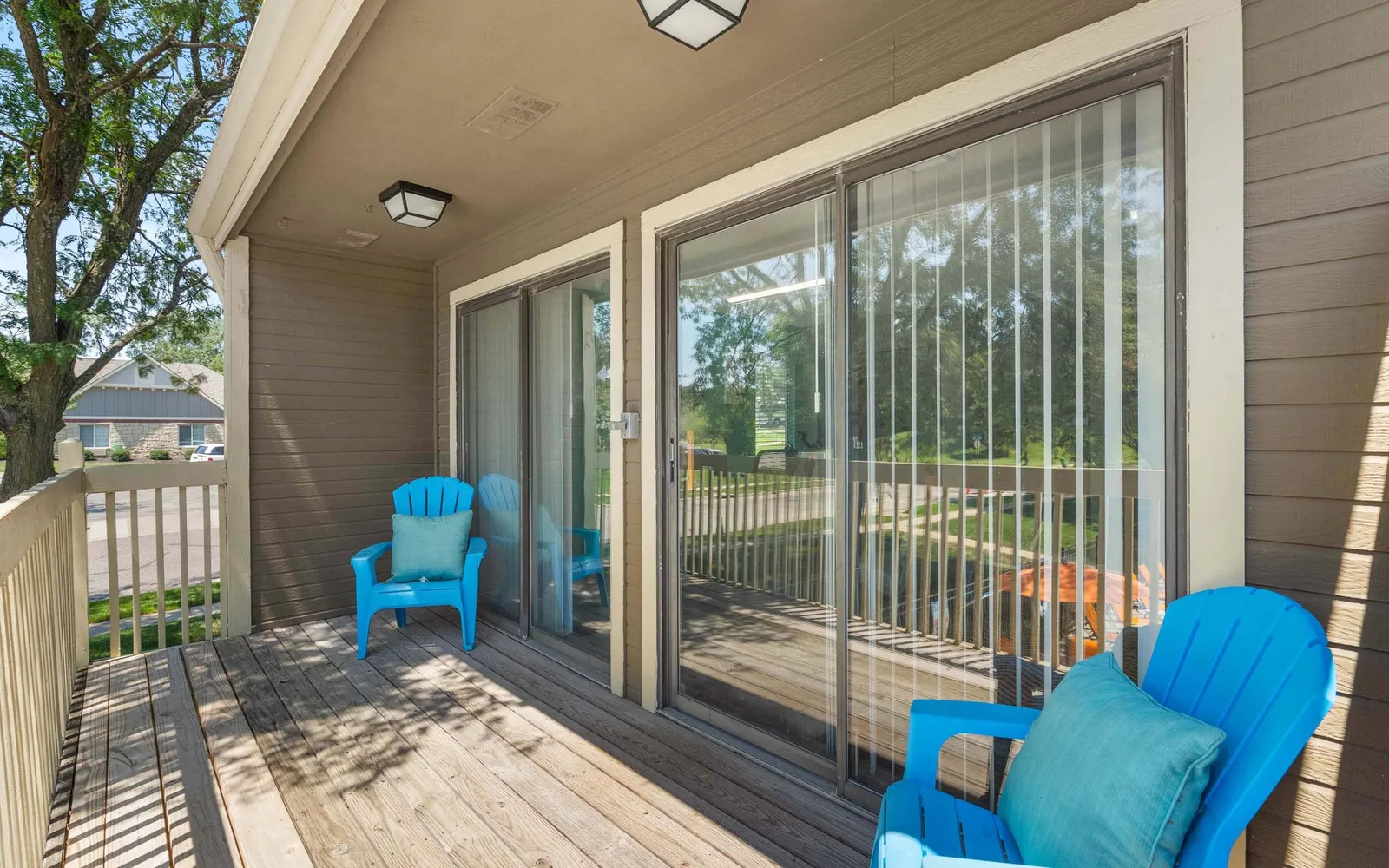 The Retreat at Woodridge - a patio with two blue chairs and large windows